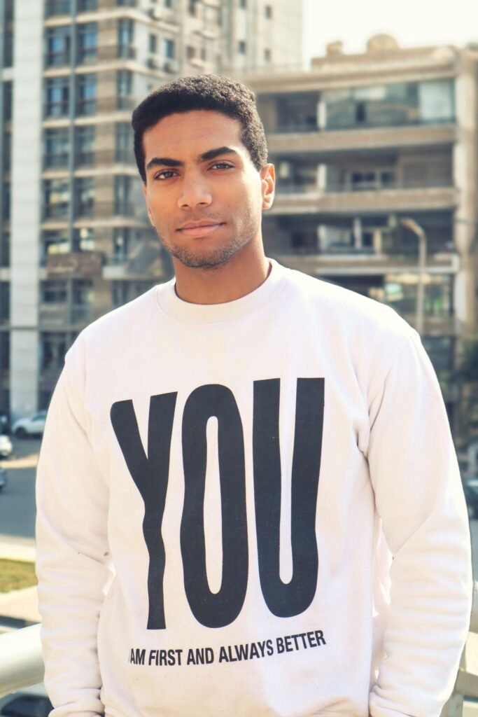 Man wearing a white graphic sweatshirt outdoors