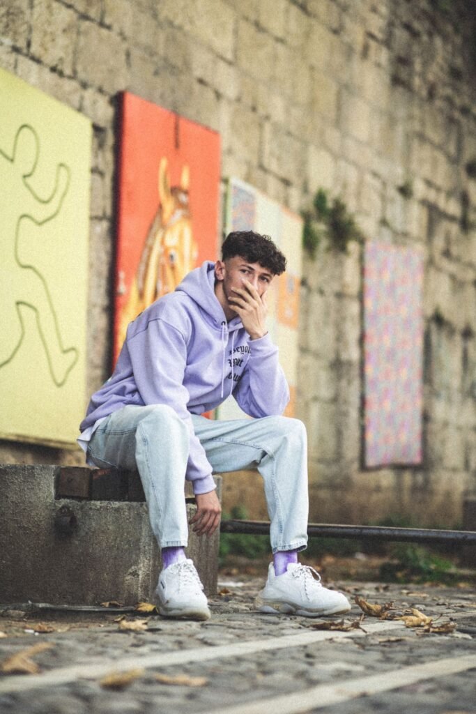 Man wearing a lavender hoodie with light jeans and sneakers