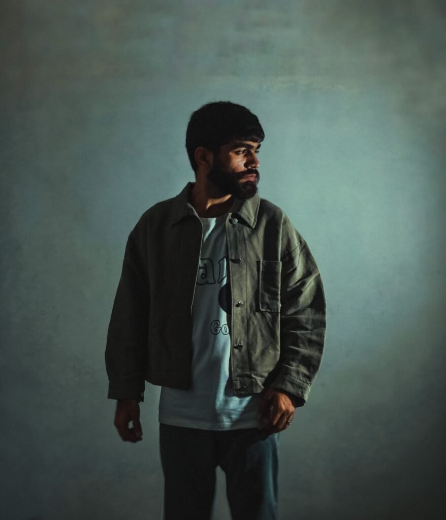 Casual menswear jacket layered over a button-front shirt