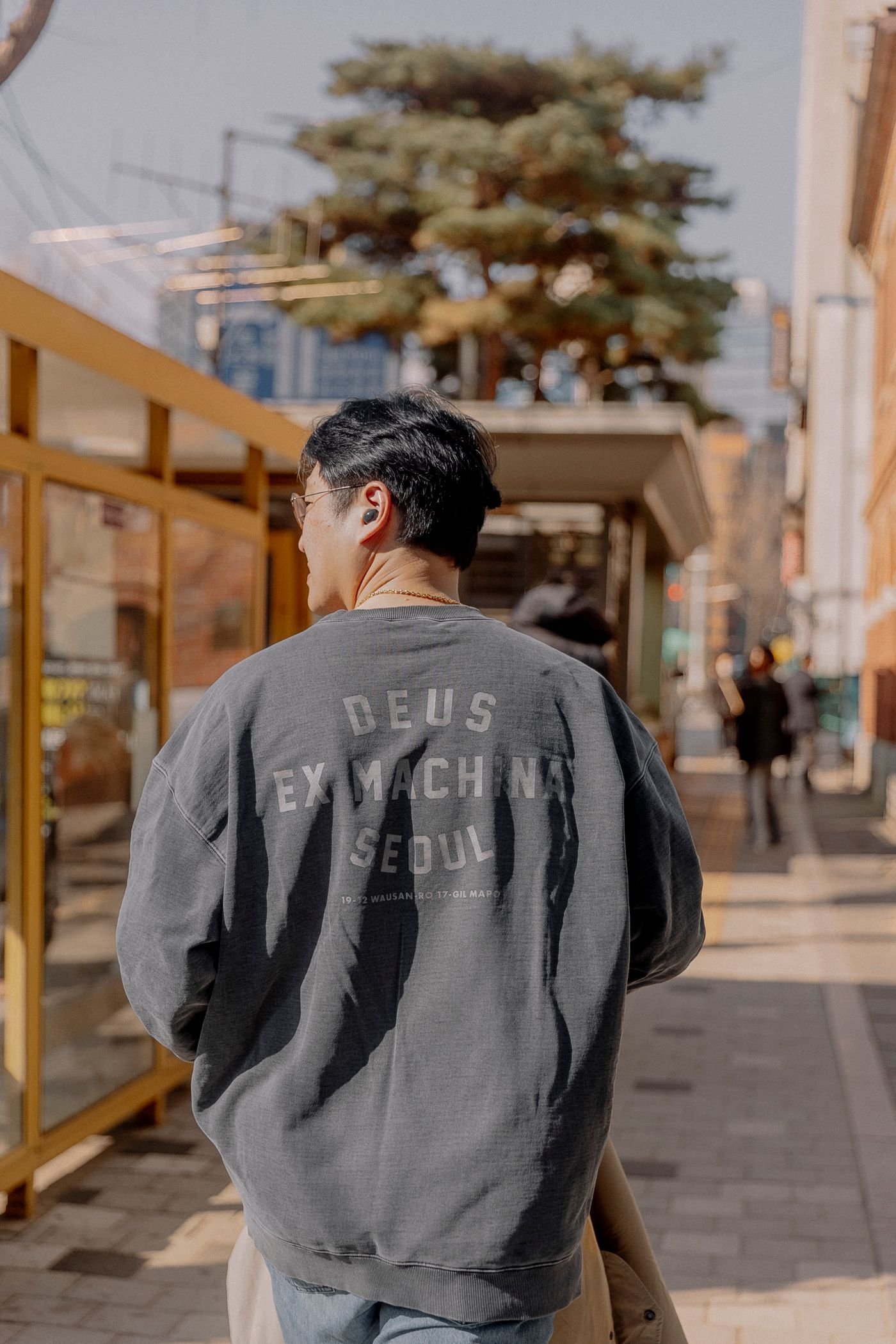 Back view of a gray graphic sweatshirt styled for the street
