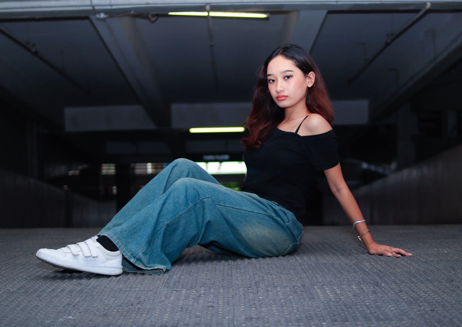 Woman wearing a black top and jeans in an urban setting