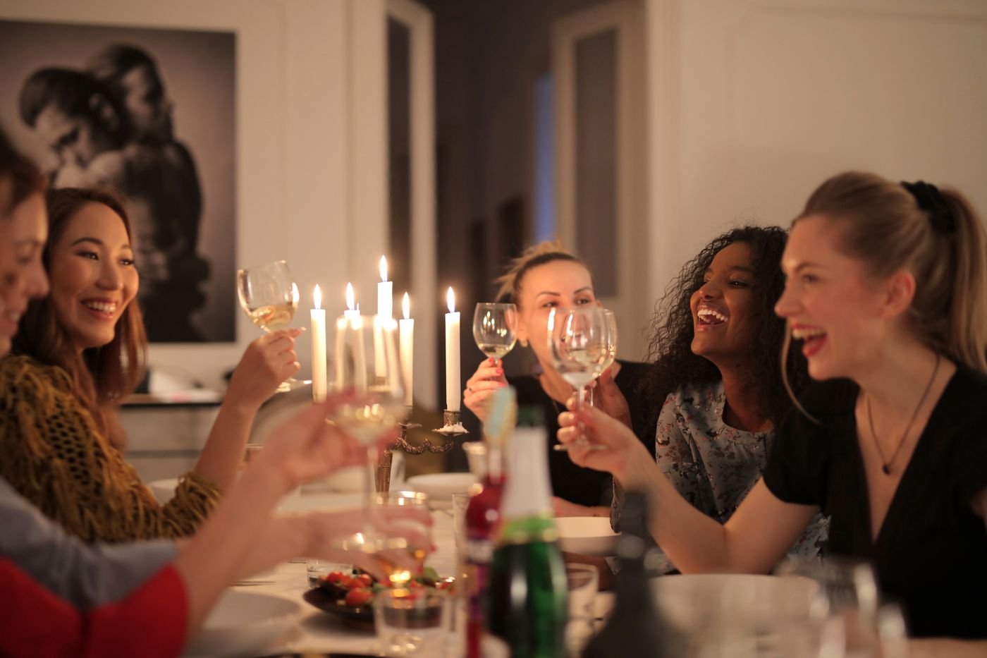 Women enjoying dinner together in a warmly lit room