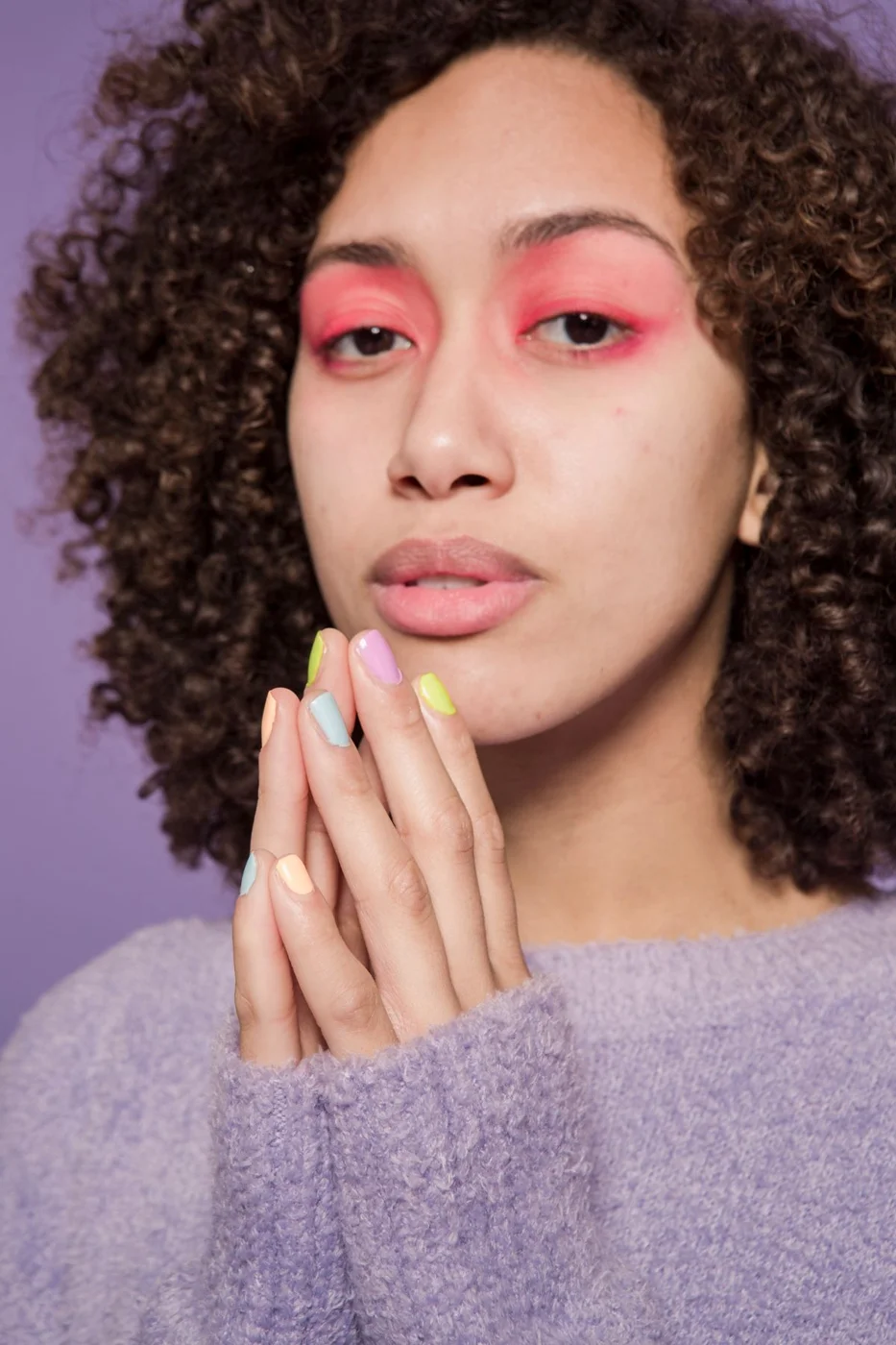 Alternate view of a pastel manicure against a purple background
