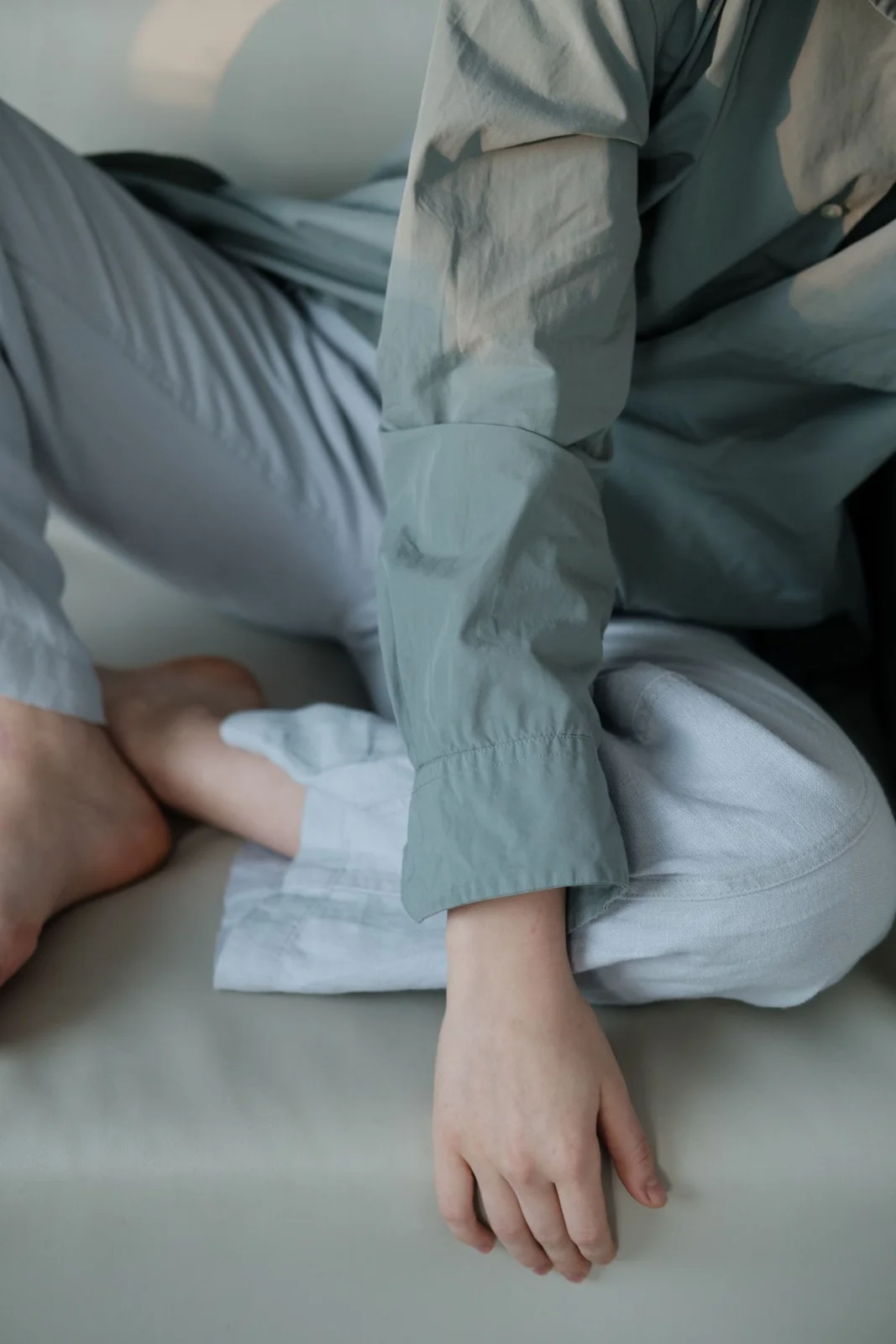 Close-up of a pale blue trouser outfit while sitting on a couch