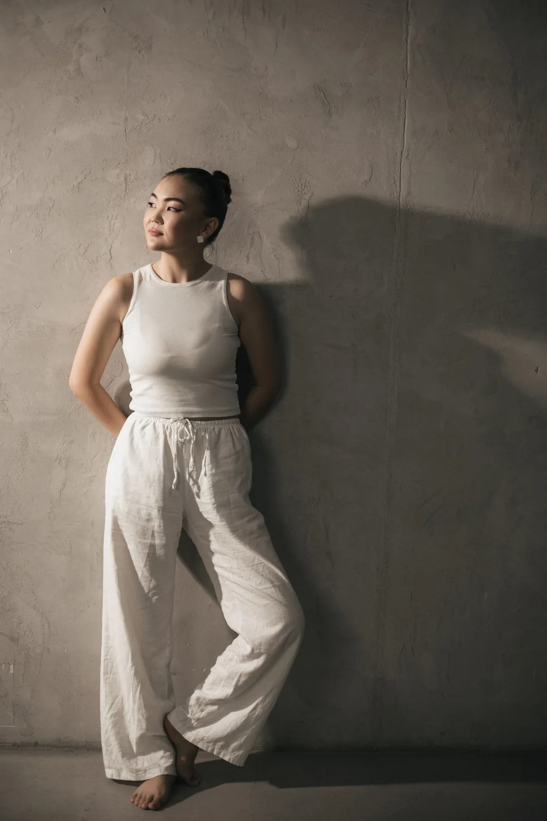 Wide-leg pale trousers styled with a fitted white tank