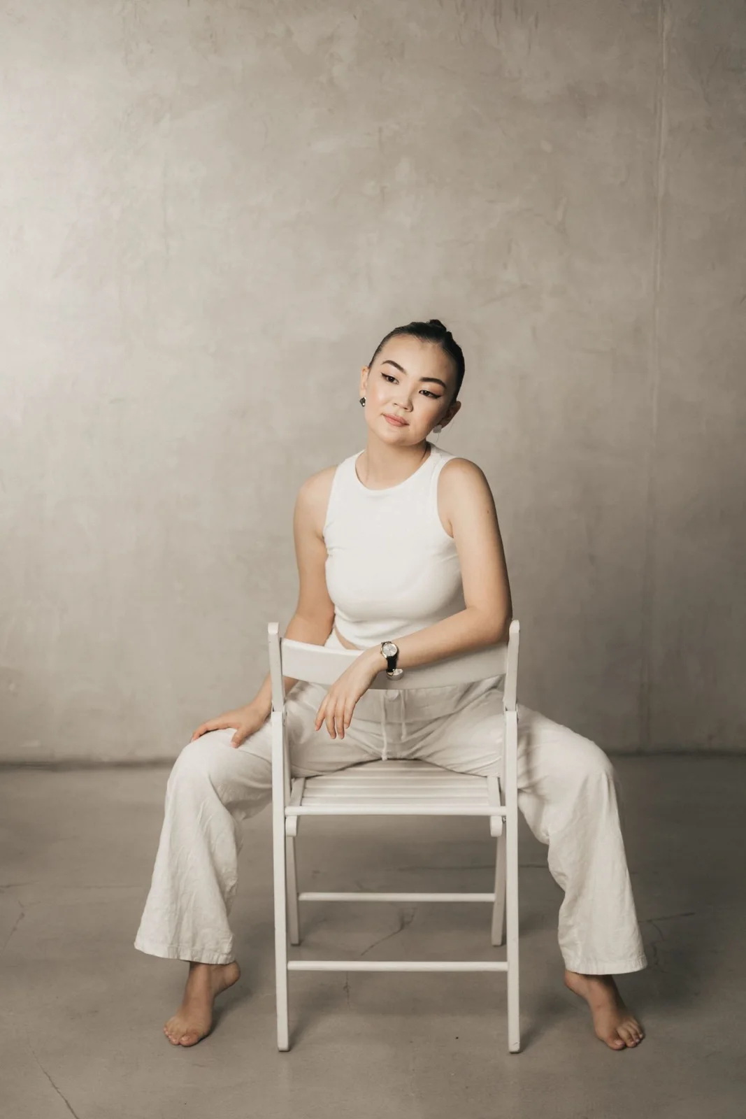 Seated view of pale trousers with a white sleeveless top